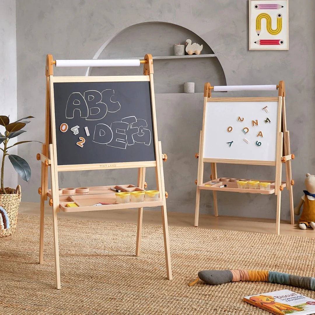 Two children's easels, one with a blackboard and the other with a whiteboard, in a room setting.